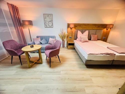 een slaapkamer met een bed, een bank en een tafel bij Apartment „Amalia“ in Ergersheim