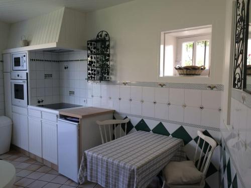 une cuisine avec une table, une table et une table dans l'établissement Location cure ou vacances dans maison charentaise centre ville, à Saujon