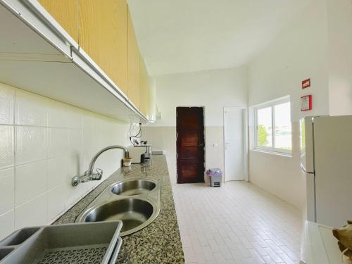 a kitchen with a sink and a refrigerator at Casa da praia in Aljezur