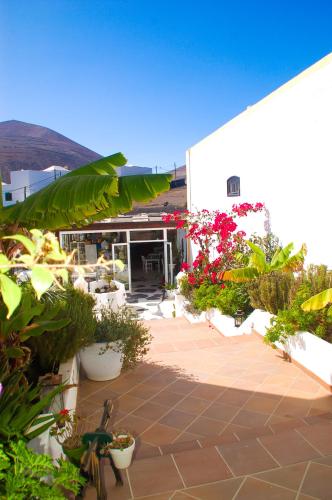 a patio with potted plants and flowers in front of a building at HOTELITO RURAL GA7COLORES only adult in Montaña Blanca