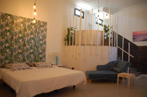 a bedroom with a bed and a blue chair at HOTELITO RURAL GA7COLORES only adult in Montaña Blanca