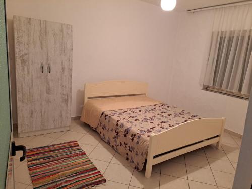 ein kleines Schlafzimmer mit einem Bett und einem Schrank in der Unterkunft Petro's House in Shkodra