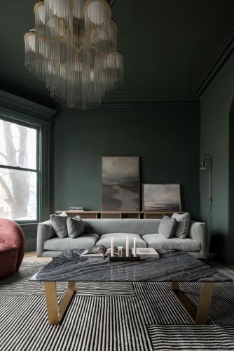a living room with a couch and a table with candles at Dvele Inn in St. John's