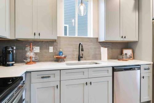 a kitchen with white cabinets and a sink at Zydeco house*Lafayette's best kept secret*Book now in Lafayette