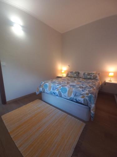 a bedroom with a bed with two lamps on it at Levadinha - Nature guest house in Madalena do Mar