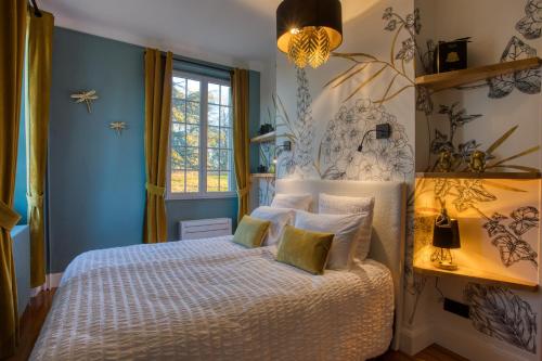 une chambre avec un lit aux murs bleus et une fenêtre dans l'établissement Manoir Majoral, à Vitrac