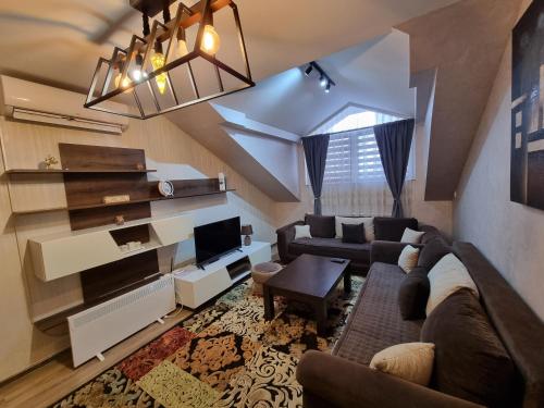 ein Wohnzimmer mit einem Sofa und einem TV in der Unterkunft Avio Apartmani 2018 in Novi Pazar