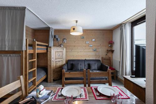 ein Wohnzimmer mit einem Tisch, einem Sofa und einem Etagenbett in der Unterkunft Résidence Roc De Peclet 2 - Studio pour 4 Personnes 414 in Val Thorens