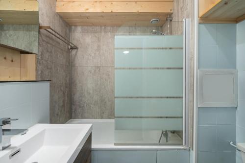 ein Bad mit einer Glasdusche und einem Waschbecken in der Unterkunft Résidence Roc De Peclet 2 - Studio pour 4 Personnes 414 in Val Thorens