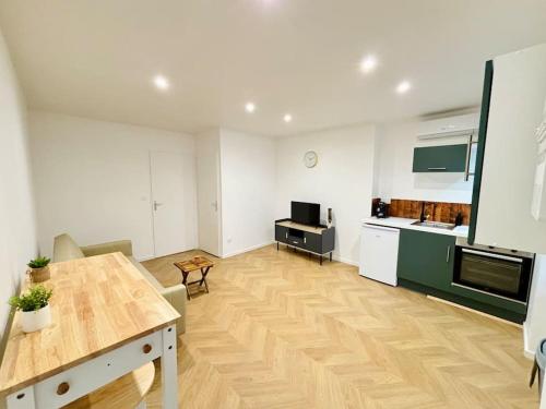 een woonkamer met een keuken en een eettafel bij Bel appartement proche gare #3 in Bourgoin