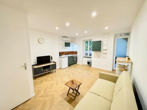 een woonkamer met een bank en een keuken bij Bel appartement proche gare #3 in Bourgoin