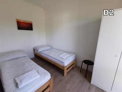a small room with two beds and a table at DM DOMKI Kościelna 54 in Mielno