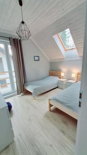 a bedroom with two beds and a skylight at Fiszka in Pobierowo