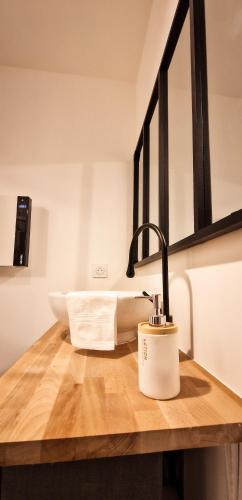 La salle de bains est pourvue d'un lavabo et d'un robinet sur un comptoir en bois. dans l'établissement L'Indus 3 étoiles Wifi, Netflix, Disney, Coeur de Bastide, à Villefranche-de-Rouergue