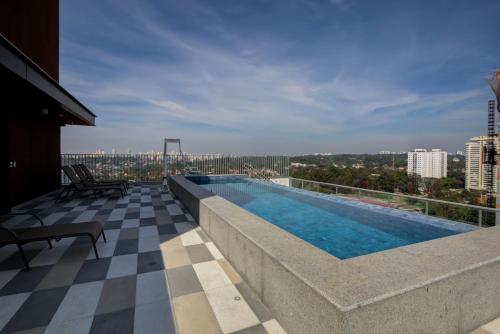 uma piscina no telhado de um edifício em Roomo Be Urban Brooklin Residencial em São Paulo