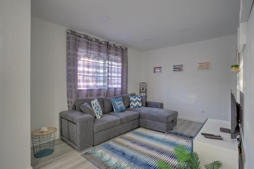 a living room with a couch and a window at Cantinho a Sul II - Costa Nova in Gafanha da Encarnação