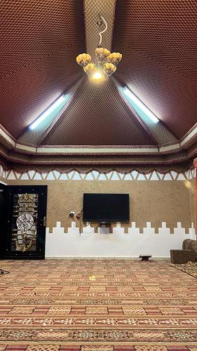 a large room with a television and a ceiling at شالية الفارس in AlUla