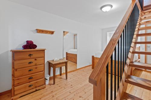 a room with a staircase and a dresser and a stair case at The Cabins at Terrace Beach in Ucluelet