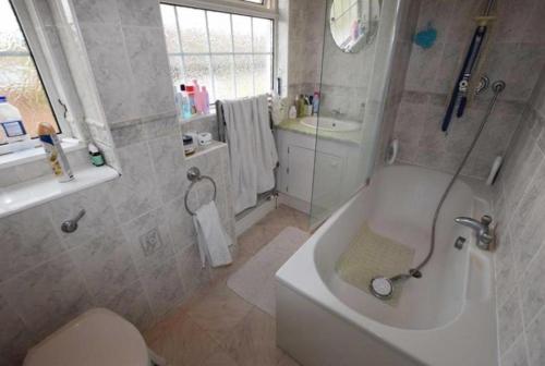 a bathroom with a tub and a toilet and a sink at 8 Warren close Stanford-Le-Hope in Stanford-le-Hope