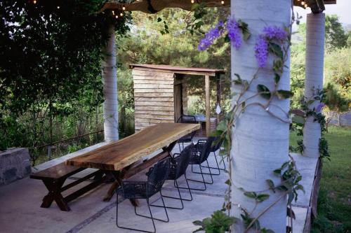 a wooden table and chairs under a gazebo at cabaña las chachalacas,hermoso espacio natural in Colima