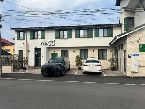 two cars parked in a parking lot in front of a building at No. 55 in Buzau