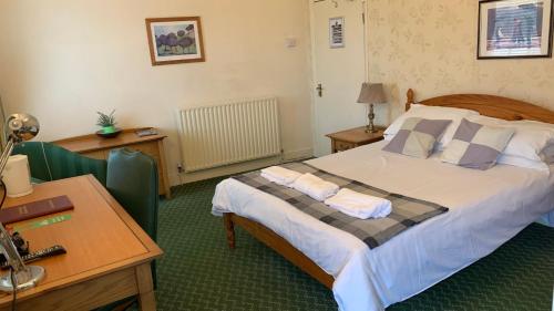 een slaapkamer met een bed met 2 kussens erop bij The Bell Hotel in Burgh le Marsh