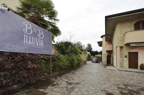 una señal en el lateral de un edificio al lado de una calle en ILLUVIA affitto camere, en Cornaredo