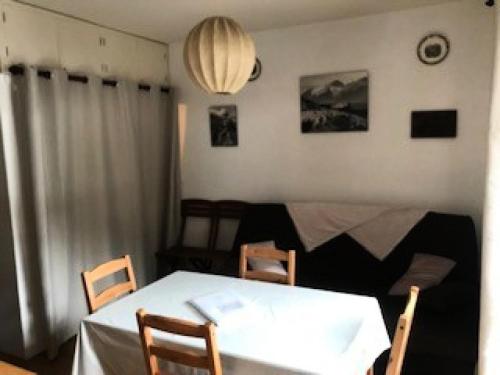 une salle à manger avec une table et des chaises blanches dans l'établissement Résidence Les Avenieres - 2 Pièces pour 4 Personnes 494, à Villarodin-Bourget