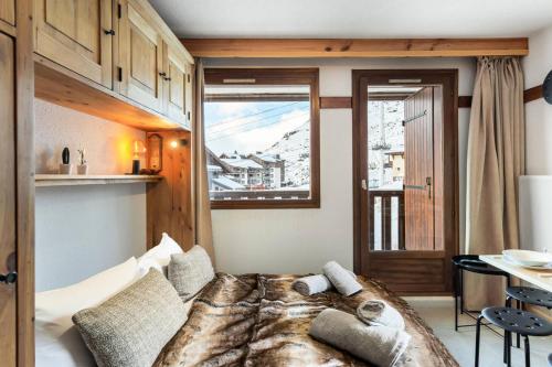 Un dormitorio con una cama grande y una ventana en Résidence La Reine Blanche - Studio pour 4 Personnes 244, en Val Thorens
