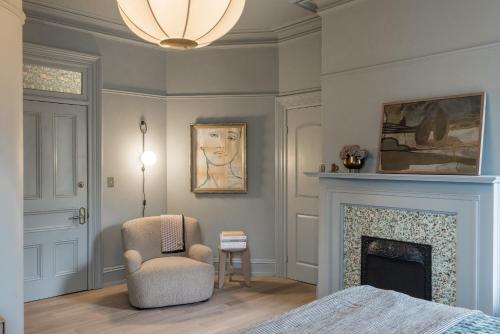 a bedroom with a chair and a fireplace at Dvele Inn in St. John's