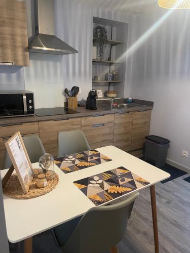 - une cuisine avec une table, des chaises et un comptoir dans l'établissement Le petit sanvignard, à Sanvignes-les-Mines