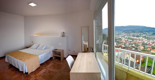 1 Schlafzimmer mit einem Bett und einem Balkon mit Aussicht in der Unterkunft Apartamentos Costas de Bueu B in Bueu
