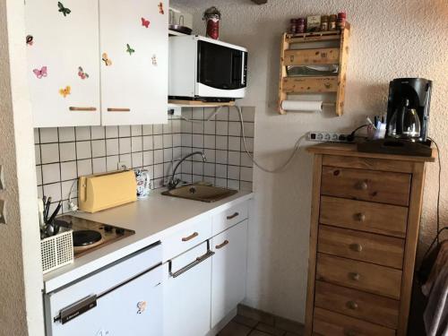 une petite cuisine avec des armoires blanches et un micro-ondes dans l'établissement Résidence Edelweiss - Edelweiss B3 MAE-0844, à Megève