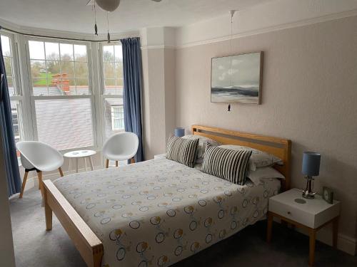 1 dormitorio con 1 cama, mesa y sillas en Channel Vista Guest House, en Combe Martin