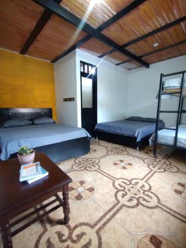 Cette chambre dispose de 2 lits, d'une table et d'une table. dans l'établissement Finca Santa Clara, Rivera-Huila, à Rivera