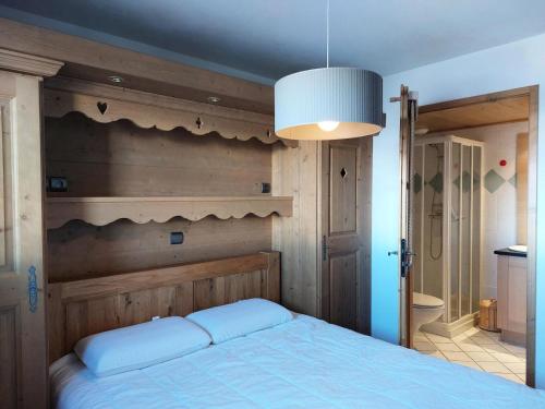 une chambre avec un lit avec une tête de lit en bois dans l'établissement Résidence L'iseran - Charmant appartement de 4 pièces dans une résidence proche des pistes dans le quartier du Chantel. MAE-3184, à Arc 1800