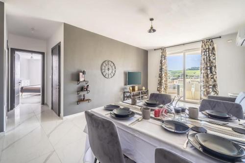 a dining room with a table and chairs and a living room at Sunset Bliss Luxury Apartment in St. Paul's Bay