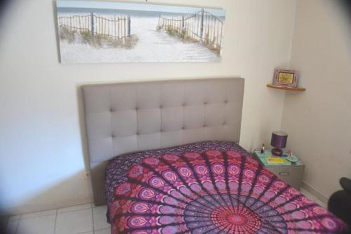 - une chambre avec un lit et une photo de la plage dans l'établissement Joli 2 pièces climatisé avec terrasse, à Cavalaire-sur-Mer