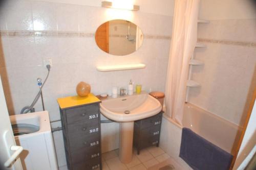 une salle de bain avec un lavabo, un miroir et une baignoire dans l'établissement Joli 2 pièces climatisé avec terrasse, à Cavalaire-sur-Mer