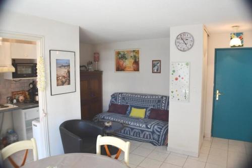 un salon avec un canapé et une horloge au mur dans l'établissement Joli 2 pièces climatisé avec terrasse, à Cavalaire-sur-Mer