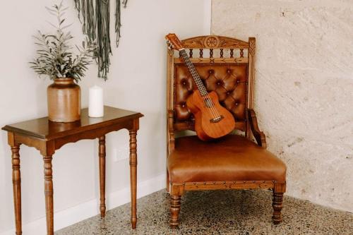 a guitar sitting on a chair next to a table at Glenberrie Place ECO Retreat in Kangarilla