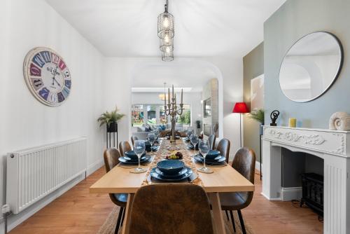 comedor con mesa, sillas y chimenea en 5 Bed Chic Modern House, Spacious - Sleeps 11, Off-Road Parking - Great for groups & Contractors - By Blue Puffin Stays en Waterlooville