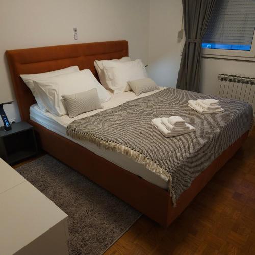 a bed with two towels on top of it at Apartman Dory in Zagreb