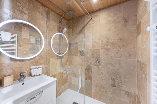 uma casa de banho com um chuveiro, um lavatório e um espelho. em Résidence OrsiÈre - 2 Pièces pour 4 Personnes 074 em Val Thorens