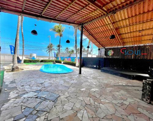 a patio with a swimming pool with a wooden roof at Soul Lounge Hostel in São Luís