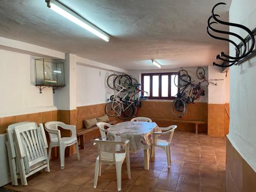 een kamer met een tafel en stoelen en fietsen aan de muur bij Casa Rural AGAPITOS 2 in Torre-Pacheco