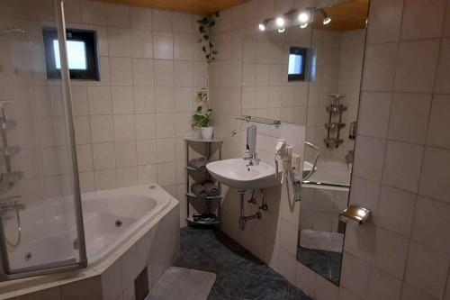 een badkamer met een bad, een wastafel en een bad bij Ferienwohnung in Weyregg am Attersee in Weyregg