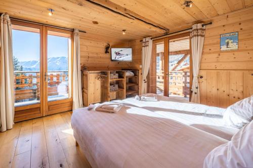 a bedroom with a large bed and a large window at Chalet Dauphin - Chalets pour 15 Personnes 264 in LʼHuez