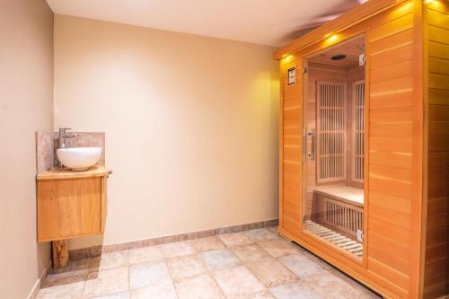 a bathroom with a walk in shower next to a wooden door at Chalet Dauphin - Chalets pour 15 Personnes 264 in LʼHuez