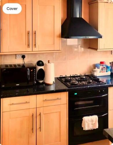 a kitchen with a stove and a black stove top oven at Cosey Room in Thornton Heath